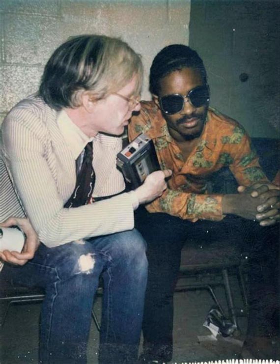 Illustration  for:   Stevie Wonder and Andy Warhol backstage at a Rolling Stones concert at Madison Square Garden in 1972. &copy; The Andy Warhol Foundation for the Visual Arts